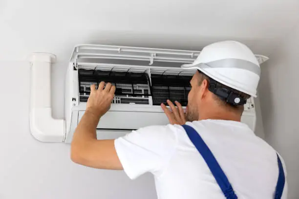 HVAC technician performing air conditioning maintenance