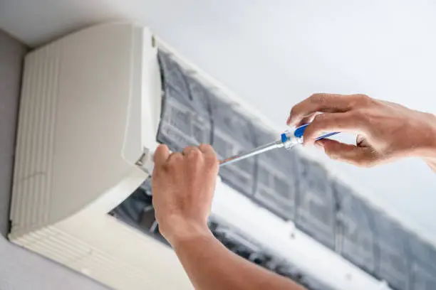 HVAC technician performing air conditioning repair process